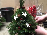 Handgebundenes Christbäumchen wird geschmückt