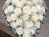 Kleines Herz mit weißen Rosen und Schleierkraut, frisch fertig gestellt und noch auf dem Arbeitstisch