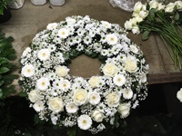 Kranz in weiß während der Fertigstellung auf dem Arbeitstisch