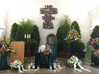 Feierhalle mit Dekorationsbäumen,  2 Gestecke in bunt, Urnenschmuck, Bilddekoration, Rosenblütenblätter, Trauerkranz 1, Kerzen und Trauerspenden